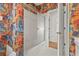Bathroom featuring a shower/tub combination, bright wallpaper, and convenient linen storage at 4180 Via Mirada, Sarasota, FL 34238