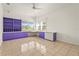 Bright bedroom with light tile floors, purple shelving, and a view of the backyard at 4180 Via Mirada, Sarasota, FL 34238