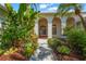 Inviting arched entryway with lush tropical landscaping leading to the front door at 4180 Via Mirada, Sarasota, FL 34238