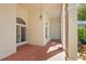 Covered outdoor entryway with tile flooring, columns, and an arched door with sidelight windows at 4180 Via Mirada, Sarasota, FL 34238
