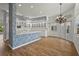Bright eat-in kitchen featuring white cabinetry, a center island, chandelier and wood floors at 4180 Via Mirada, Sarasota, FL 34238