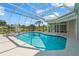 An outdoor swimming pool with hot tub and white screen enclosure offering lake views at 4180 Via Mirada, Sarasota, FL 34238