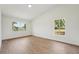 Bright bedroom featuring vinyl plank flooring, light walls, and two windows offering natural light at 4265 Hoffman Ave, Spring Hill, FL 34606