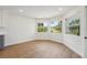 Sunlit breakfast nook with three large windows offering serene outdoor views and wood-look flooring at 4265 Hoffman Ave, Spring Hill, FL 34606