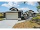 Charming single-story home featuring a two-car garage, arched entry and manicured lawn on a sunny day at 4265 Hoffman Ave, Spring Hill, FL 34606