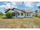 Exterior view of the home features a screened porch and a fenced backyard under a partly cloudy sky at 4265 Hoffman Ave, Spring Hill, FL 34606
