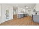 A modern kitchen featuring white and grey cabinets, stainless steel appliances, and wood-look vinyl flooring at 4265 Hoffman Ave, Spring Hill, FL 34606