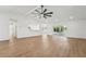 Open living room with a ceiling fan, breakfast bar, sliding glass doors, and wood-look floors at 4265 Hoffman Ave, Spring Hill, FL 34606