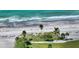 Aerial view of beach with clear water, palm trees and pathways through the green space at 4800 Gulf Of Mexico Dr # 204, Longboat Key, FL 34228