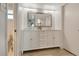 Modern bathroom featuring double sinks, marble countertop, and white hexagon tile accent wall at 4800 Gulf Of Mexico Dr # 204, Longboat Key, FL 34228