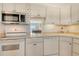 Bright kitchen features white cabinets, appliances, and a peek-through view to the dining area at 4800 Gulf Of Mexico Dr # 204, Longboat Key, FL 34228