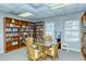 Community library with wooden bookshelves, reading table, chairs, and window for a quiet space to read at 4800 Gulf Of Mexico Dr # 204, Longboat Key, FL 34228