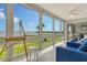 Bright sunroom with large windows offering expansive water views, an easel, and comfortable blue seating at 4800 Gulf Of Mexico Dr # 204, Longboat Key, FL 34228