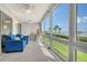 Inviting sunroom featuring bright windows with water views, comfortable blue seating, and tiled floors at 4800 Gulf Of Mexico Dr # 204, Longboat Key, FL 34228