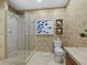 Bathroom featuring a glass shower enclosure and earth-toned wall coverings at 50 Central Ave # 17Phd, Sarasota, FL 34236