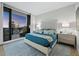 Beautiful bedroom with tufted headboard bed, balcony access and a plush area rug over wood floors at 50 Central Ave # 17Phd, Sarasota, FL 34236