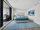 Modern bedroom featuring tufted headboard bed, balcony access, and a plush area rug over wood floors at 50 Central Ave # 17Phd, Sarasota, FL 34236