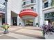Eye-catching building entrance featuring a red awning, glass doors, and lush landscaping at 50 Central Ave # 17Phd, Sarasota, FL 34236