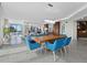 Open dining area with modern blue chairs and views of the living room and the ocean at 50 Central Ave # 17Phd, Sarasota, FL 34236