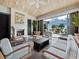 Living room area leading out to pool deck through glass doors; fireplace, chairs, and tables included at 50 Central Ave # 17Phd, Sarasota, FL 34236