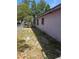 Side yard with a grassy area, a chain-link fence, and an exterior wall at 519 36Th E Ave, Bradenton, FL 34208