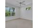 Bright bedroom with two windows overlooking lush green landscape, neutral walls and a ceiling fan at 5633 Key Largo Ct # B-08, Bradenton, FL 34203