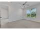 Bright bedroom with neutral walls, modern ceiling fan and view of the green landscape through window at 5633 Key Largo Ct # B-08, Bradenton, FL 34203