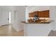 Well-lit kitchen with granite countertops, brown cabinets, and an open view into the living area at 5633 Key Largo Ct # B-08, Bradenton, FL 34203