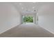 Bright living room with sliding glass doors to balcony, white walls, and modern ceiling fan at 5633 Key Largo Ct # B-08, Bradenton, FL 34203