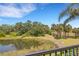 Scenic view of the pond surrounded by lush greenery and palm trees, visible from the balcony at 5633 Key Largo Ct # B-08, Bradenton, FL 34203