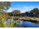 Beautiful tranquil water view with lush plants and grasses in the foreground, featuring a stone retaining wall at 5633 Key Largo Ct # B-08, Bradenton, FL 34203
