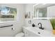 Bright bathroom showcases a modern vanity with black fixtures, illuminated mirror, and a window with a view at 578-580 Companion Way, Longboat Key, FL 34228