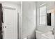 Modern bathroom with marble-like tiling, a glass shower, and washer/dryer unit at 578-580 Companion Way, Longboat Key, FL 34228