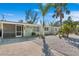Charming single-story home with a screened-in porch, a quaint bench, and lush tropical landscaping at 578-580 Companion Way, Longboat Key, FL 34228