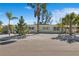 Charming exterior view of a duplex with tropical landscaping, a light-colored gravel yard, and blue skies at 578-580 Companion Way, Longboat Key, FL 34228