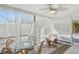 Bright sunroom with a ceiling fan, glass table, and lots of natural light, furnished with rattan chairs at 578-580 Companion Way, Longboat Key, FL 34228