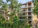 Multi-story condo building featuring private balconies, stair access, and lush tropical landscaping at 6470 Mourning Dove Dr # 201, Bradenton, FL 34210