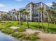 Beautiful condo building situated on a waterfront property with lush green lawn and palm trees at 6470 Mourning Dove Dr # 201, Bradenton, FL 34210