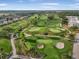 Aerial view of a lush golf course surrounded by homes and trees on a sunny day at 6470 Mourning Dove Dr # 201, Bradenton, FL 34210