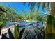 Community pool surrounded by lounge chairs and tropical plants, offering a relaxing resort-style experience at 6470 Mourning Dove Dr # 201, Bradenton, FL 34210
