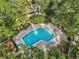 Aerial view of a beautiful community pool surrounded by lush tropical landscaping and plenty of lounge chairs at 6470 Mourning Dove Dr # 201, Bradenton, FL 34210