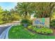 Entrance to Wild Oak Bay featuring lush landscaping and a stone sign, creating an inviting community entrance at 6470 Mourning Dove Dr # 201, Bradenton, FL 34210