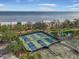 Aerial view of outdoor tennis courts, pickleball courts, and water views at 6470 Mourning Dove Dr # 201, Bradenton, FL 34210