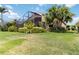 Lush backyard featuring well-maintained lawn, tropical landscaping, and screened lanai at 6519 43Rd E Ct, Sarasota, FL 34243