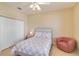 Bedroom features tiled floors, a floral bed set, and a comfortable seating area at 6519 43Rd E Ct, Sarasota, FL 34243