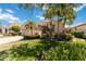 Single Gathering home with lush landscaping, mature palm trees, and brick driveway at 6519 43Rd E Ct, Sarasota, FL 34243