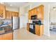 Well-lit kitchen features wood cabinets, stainless steel refrigerator, and black appliances at 6519 43Rd E Ct, Sarasota, FL 34243