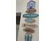 Playful beach-themed wall decor with stacked signs including 'Beach', 'Relax,' and 'Enjoy' at 6610 Midnight Pass Rd # 11, Sarasota, FL 34242