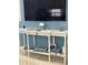 A stylish console table against a blue wall, adorned with a TV and decorative items at 6610 Midnight Pass Rd # 11, Sarasota, FL 34242
