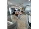 A stylish open-concept living room featuring a modern sofa, sleek kitchen, and dining area at 6610 Midnight Pass Rd # 11, Sarasota, FL 34242